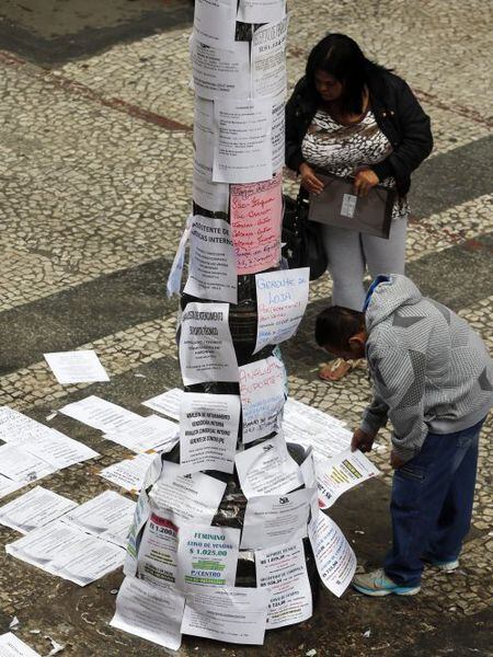 Transeuntes leem ofertas de trabalho em São Paulo.