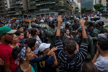 Manifestantes enfrentam membros da Guarda Nacional Bolivariana, em Caracas, em protesto contra a falta de alimentos.