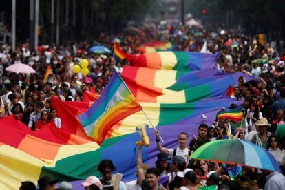 Os participantes do desfile anual do dia do orgulho gay sustentam uma grande bandeira de arco íris na cidade de México.