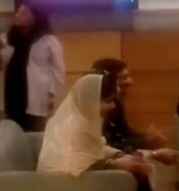 Imagem de televisão em que Malala aparece sentada junto à sua família no aeroporto de Islamabad, na manhã desta quinta.