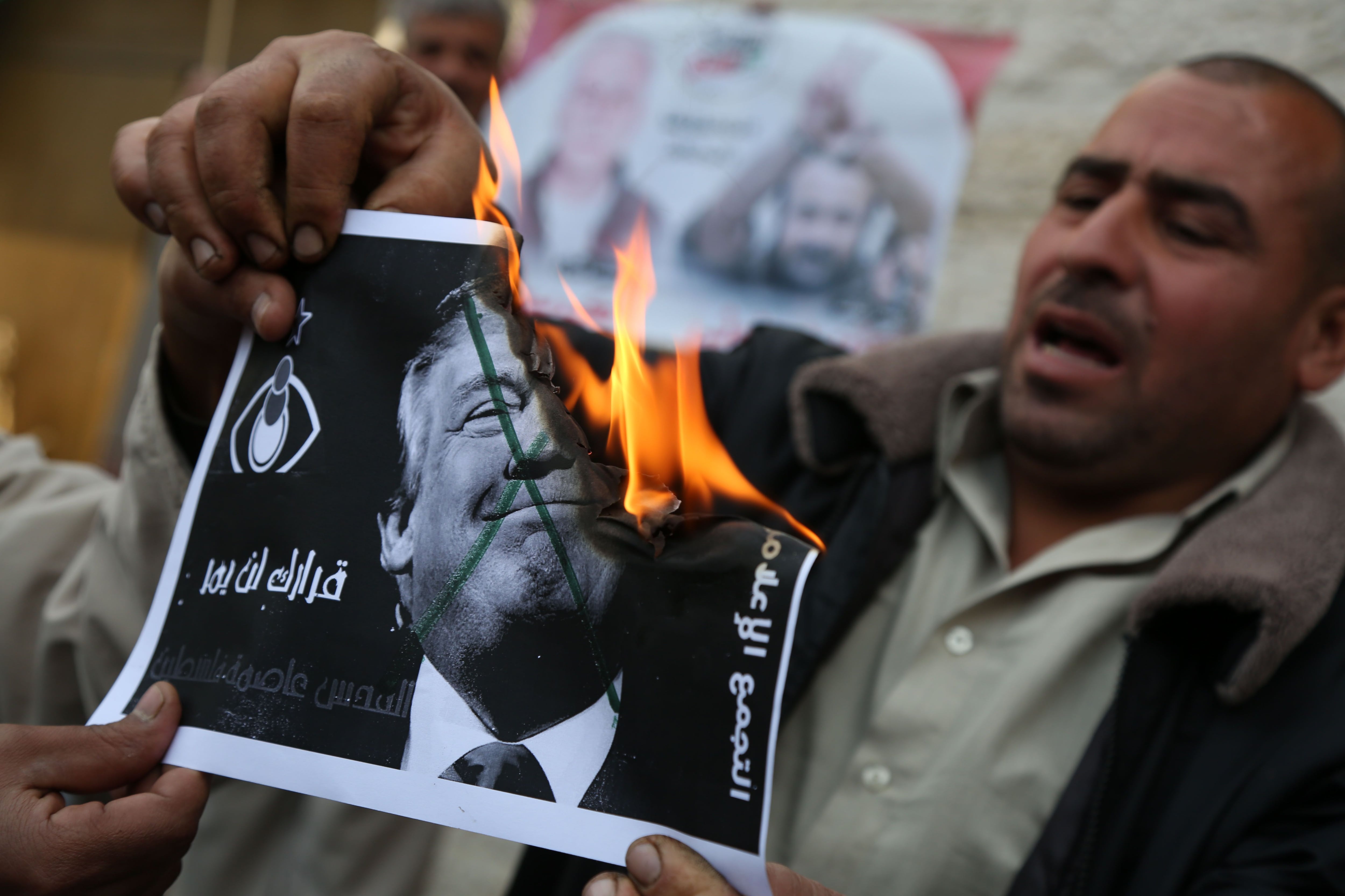 Um palestino queima imagen de Donald Trump durante protesto em Gaza contra o reconhecimento de Jerusalém como capital de Israel, em 2017. 