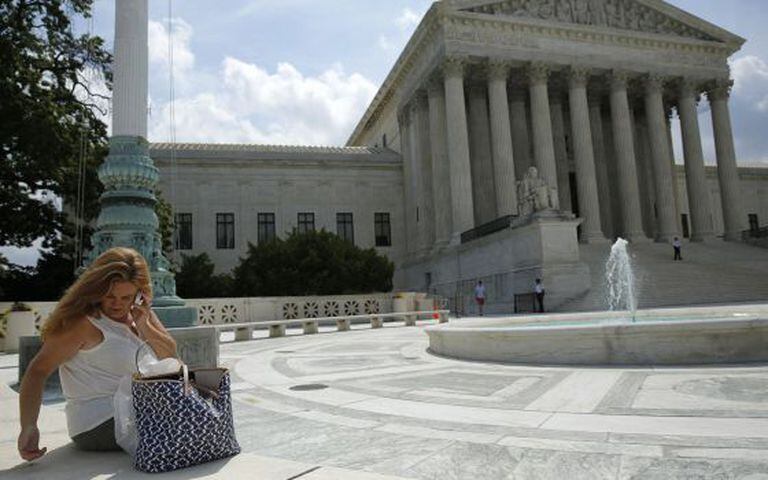 Uma mulher usa seu celular diante do Tribunal Supremo.