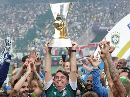 Bolsonaro ergue a taça de campeão do Palmeiras no Allianz Parque.