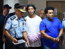 Ronaldinho aparece algemado ao lado do irmão ao chegar no Palácio da Justiça de Assunção, neste sábado.