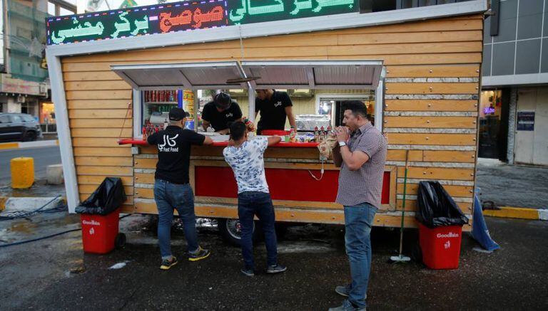 Três iraquianos em um restaurante de rua de Bagdá.