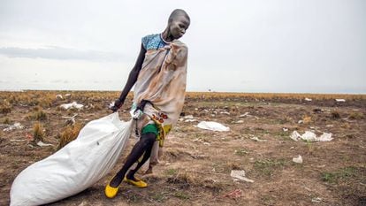 Mulher arrasta saco de comida jogado do alto pelo Programa Mundial de Alimentos no Sudão do Sul