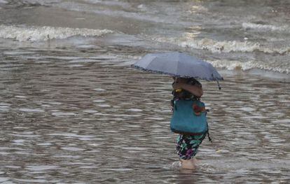 Mulher circula por rua alagada em São Paulo, após as fortes chuvas desta sexta-feira.