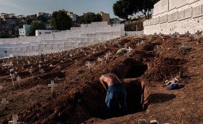 Um coveiro exausto cava uma cova no cemitério do Pechincha na zona Oeste do Rio de Janeiro.