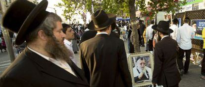 Judeus ultraortodoxos caminham ao lado de um retrato do líder espiritual já morto, o sefardita Ovadia Yosef, em outubro em Jerusalém.