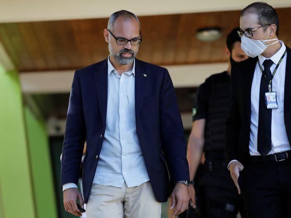 Allan dos Santos, journalist and supporter of Brazil's President Jair Bolsonaro, is seen next to a Federal Police Agent during a fake news investigation in his home, amid the coronavirus disease (COVID-19) outbreak, in Brasilia, Brazil May 27 2020. REUTERS/Adriano Machado