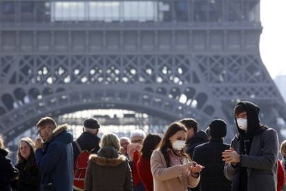 Dois turistas com máscara para evitar o coronavírus, em frente à Torre Eiffel de Paris. 