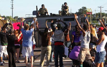 Manifestantes diante de um veículo blindado em Ferguson.