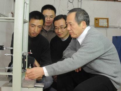 O físico Luo Jun (direita) e sua equipe, junto a um de seus aparelhos.
