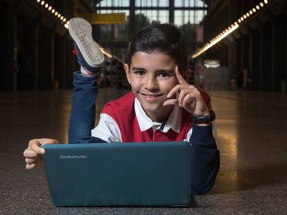 Antonio García Vicente, de 11 anos, posa com o computador no qual programa.
