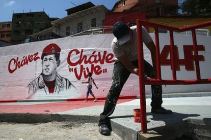 Homens pintando um mural em homenagem a Chávez.