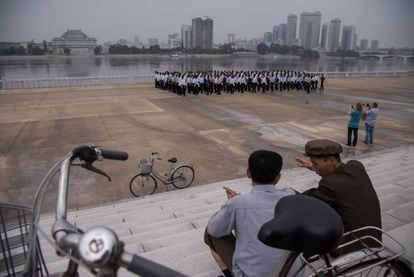 Turistas tiram foto no rio Taedong, em Pyongyang