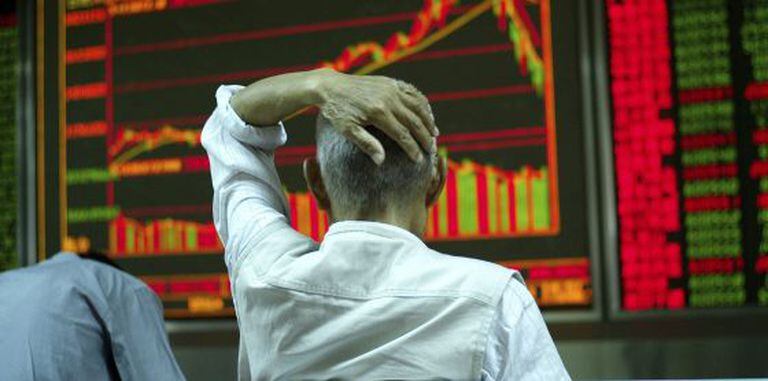 Investidor checa uma tela com informações sobre ações em Pequim.
