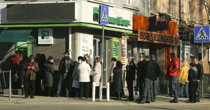 Pessoas fazem fila para tirar dinheiro de um banco em Simferopol.