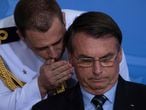 Un militar habla al oído del presidente Bolsonaro en una ceremonia en Brasilia en marzo.