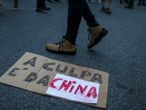 A person walks past a sign laying on the ground that reads: "It's China's fault" as supporters of Brazil's President Jair Bolsonaro take part in a protest blaming China for being the country where the coronavirus disease (COVID-19) started, in front of the Chinese consulate in Rio de Janeiro, Brazil May 17, 2020. REUTERS/Pilar Olivares