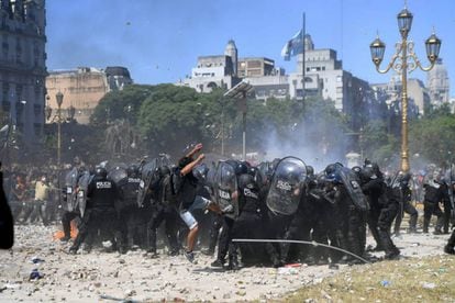 Manifestantes cercam grupo de policiais durante os distúrbios em frente ao Congresso argentino.