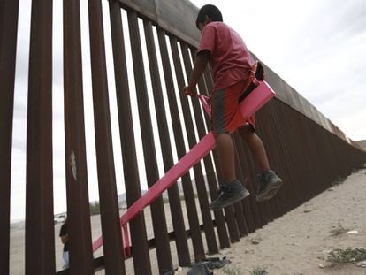 Criança brinca no muro em Ciudad Juárez.