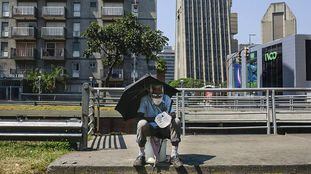 Un hombre pide limosna sentado en la avenida Libertador de la capital de Venezuela.