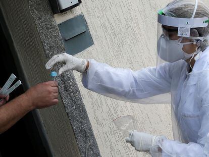 Homem recebe na terça, 14 de abril, um teste de coronavírus de um profissional da saúde na porta de sua casa, em São Caetano do Sul, São Paulo.
