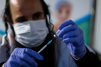 Trabalhador prepara dose da vacina da Pfizer para aplicação em Jerusalém, no domingo.