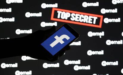 Pessoa segura um celular com o logo do Facebook sobre uma tela com as palavras 'top secret' e '@email'.