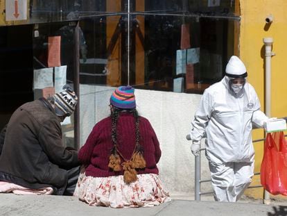 Trabalhador da saúde sai de um hospital em La Paz (Bolívia) meses atrás, equipado com a proteção para a covid.