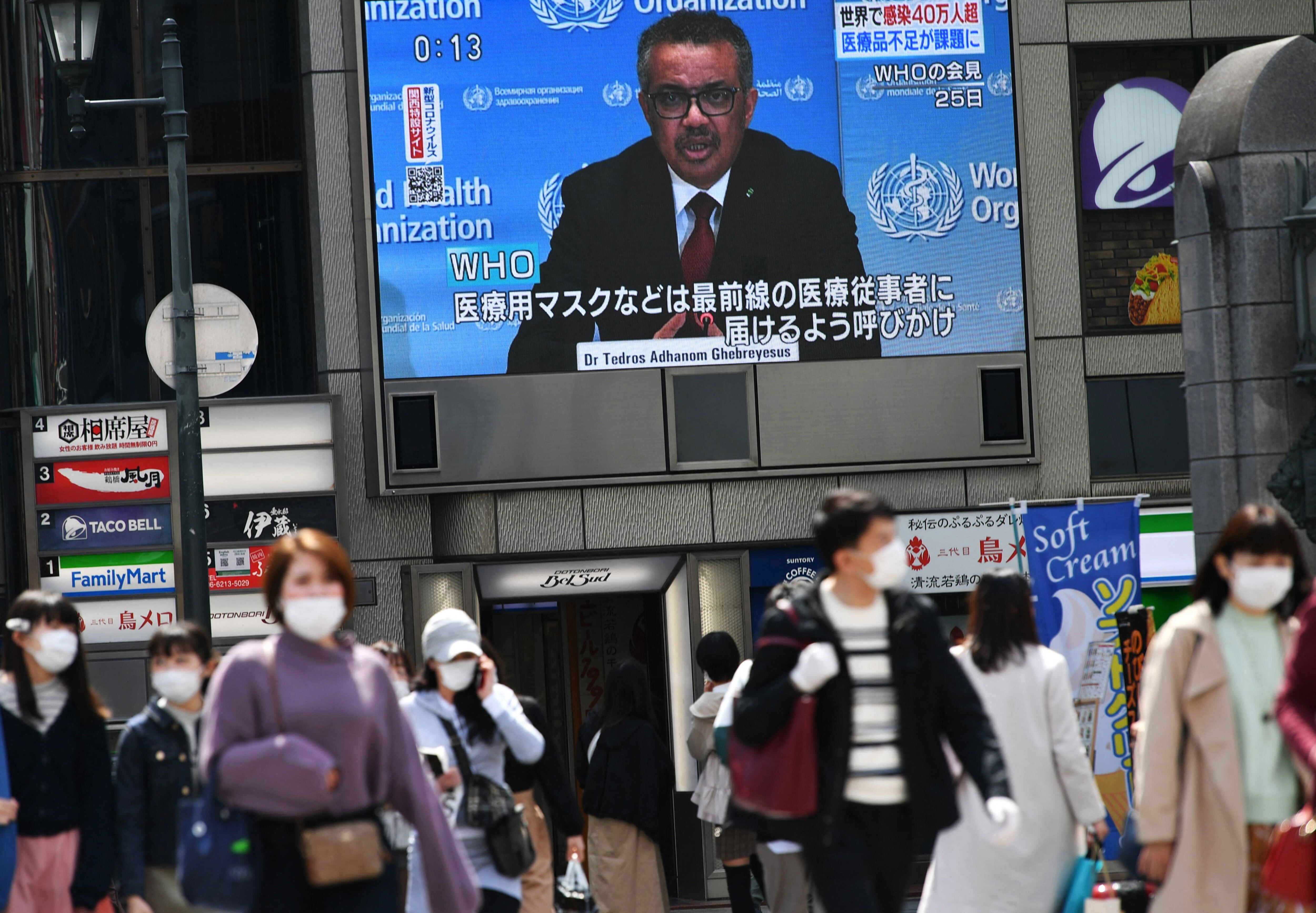Coletiva do diretor-geral da OMS, Tedros Adhanom Ghebreyesus, numa tela gigante em Osaka (Japão), em março de 2020. 