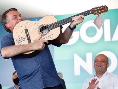 O presidente Jair Bolsonaro simula que o violão é uma arma durante um encontro com líderes políticos do Goiás, no sábado, 28 de agosto.