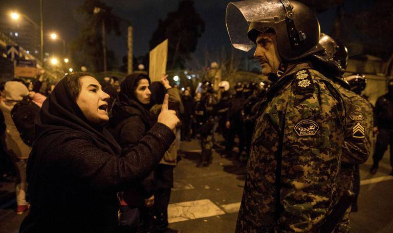 Mulher se dirige a um policial durante vigília, no sábado, pelas vítimas do voo da Ukraine International Airlines abatido pelo Irã, concentração que se transformou em um protesto antigovernamental.