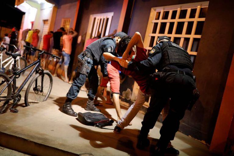 Policias revistam homem venezuelano durante operação em Boa Vista, capital de Roraima.