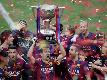 Xavi ergue a taça de campeão da Liga pelo Barcelona.