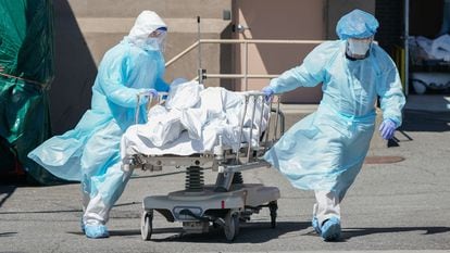 Trabalhadores transportam um corpo no hospital Wyckoff, em Nova York, em abril.