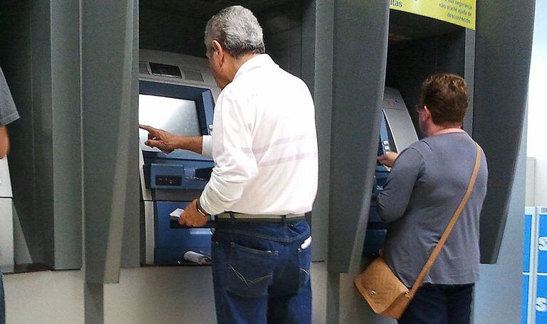 Idosos utilizam serviços bancários.