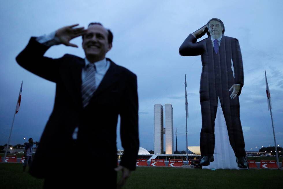 Militante ao lado de boneco inflável de Bolsonaro.