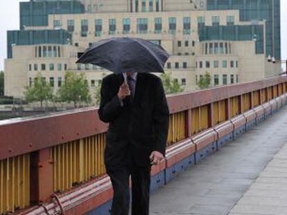 Homem caminha junto à sede do MI6 em Londres.
