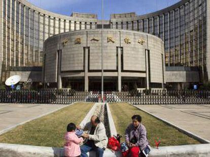 Uma família em frente ao Banco Popular da China, em Pequim.