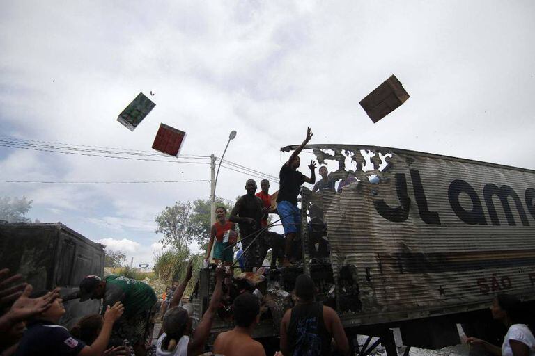 Grupo de pessoas saqueia caminhão no Rio.