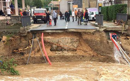 Moradores ao lado de uma ponte sobre o rio Trapel arrancada pela força da água em Villegailhenc, perto de Carcassonne.