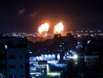 Explosions light-up the night sky above buildings in Gaza City as Israeli forces shell the Palestinian enclave, early on June 16, 2021. (Photo by Mahmud hams / AFP)
