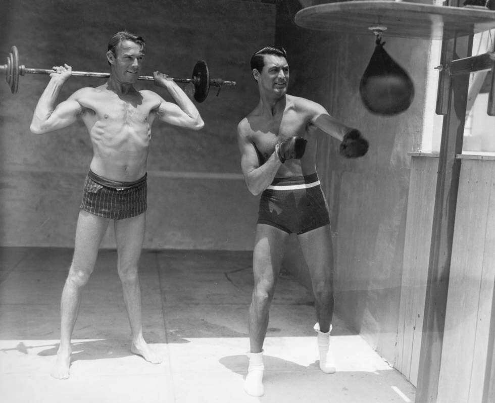 Cary Grant e Randolph Scott fazem ginástica juntos.