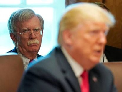 Trump com o assessor da Casa Branca, John Bolton, ao fundo.