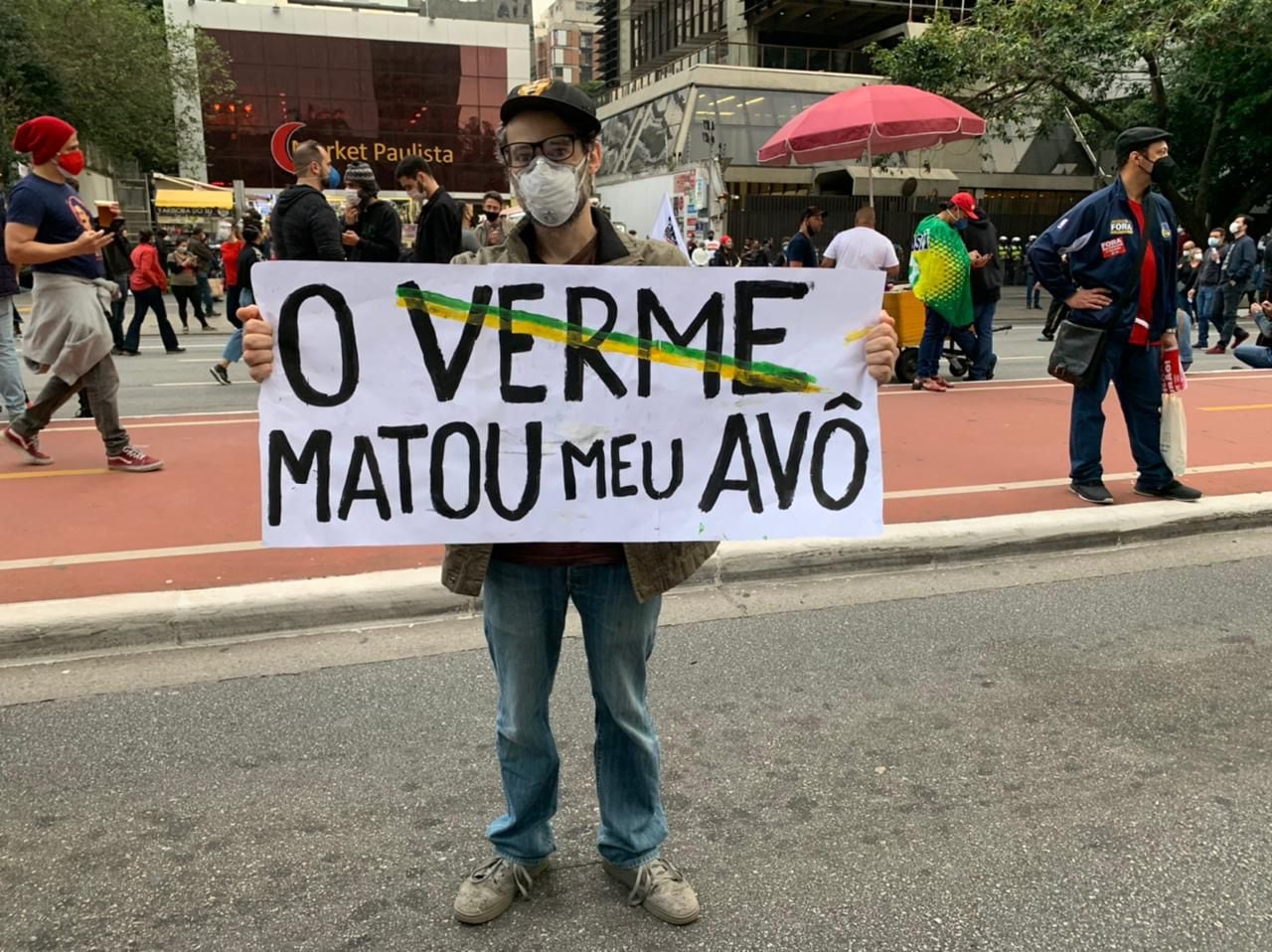 Clayton, que perdeu seu avô, exibe cartaz em protesto na avenida Paulista.