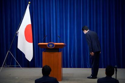 O primeiro-ministro do Japão, Shinzo Abe, se curva diante da bandeira japonesa ao anunciar a decisão de deixar o cargo que ocupa há oito anos, por motivos de saúde.