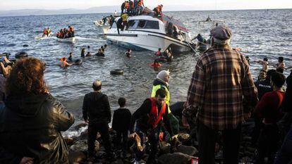 Moradores da ilha grega de Lesbos ajudam refugiados a desembarcar.