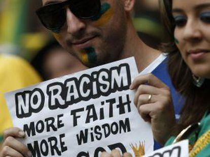 Torcedores do Brasil mostram cartazes contra o racismo.